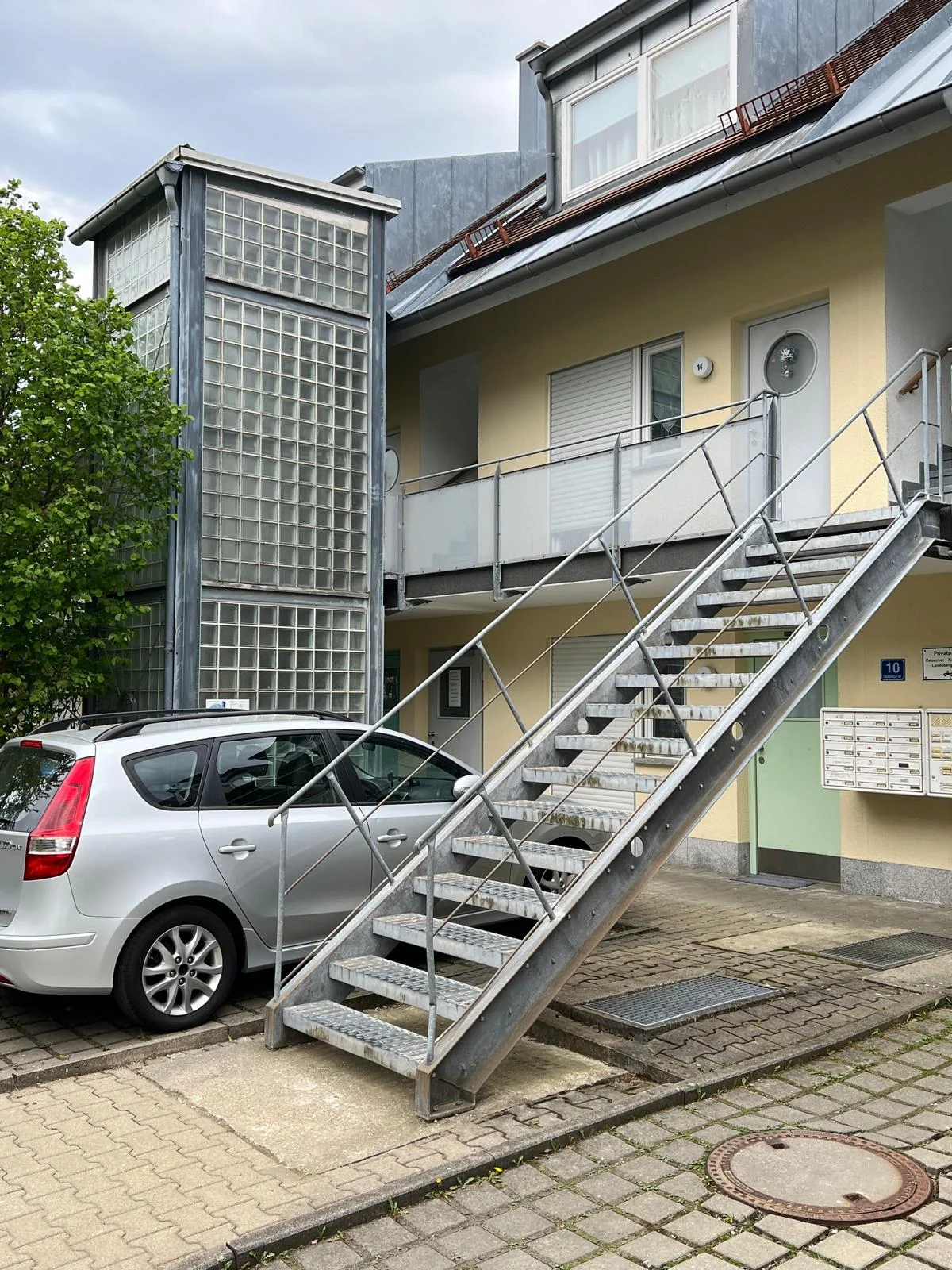 Außenliegende Aufzugsanlage mit verzinkter Stahltreppe